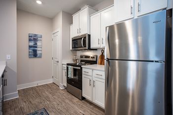 a kitchen with stainless steel appliances and white cabinets